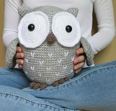 a woman is holding an owl pillow in her hands