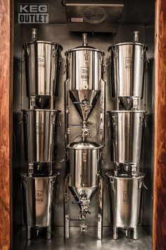 several stainless steel pots and beakers in a cabinet