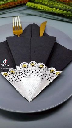 four napkins on a plate with gold forks