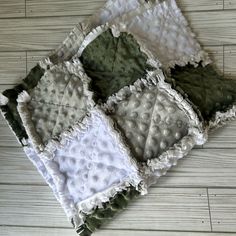 four pieces of cloth on the floor with white and green squares in them, all folded together