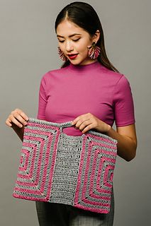 a woman is holding a crocheted purse