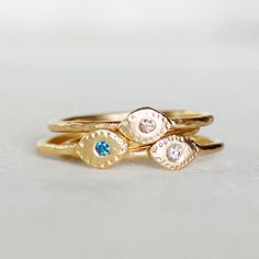 "Sparkly teal blue diamond \"Evil Eye\" ring. Diamond - 1.7mm - conflict-free, teal blue (treated to enhance color) Band - Hammered gold band...choose between 1.3mm and 1.6mm thickness Eye - 4mmx6mm Gold - 14k (18k Gold available. Pricing on request) Size - Please leave your ring size in the \"message to seller\" section at checkout **When you check out, choose: 1.3mm or 1.6mm band width...if you are stacking with one of my 1.6mm bands, choose the 1.6mm. If you are stacking it with one of my 1.3 Blue 14k Gold Stackable Promise Rings, Blue Birthstone Diamond Ring In 14k Gold, Blue 14k Gold Diamond Birthstone Ring, Blue 14k Gold Diamond Ring With Birthstone, Gold Topaz Birthstone Promise Ring, Handmade Gold Diamond Promise Ring, Blue 14k Gold Stackable Rings As Gift, Turquoise Topaz Promise Ring With Birthstone, Turquoise Topaz Birthstone Promise Ring