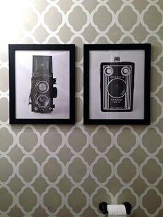 two black and white pictures hanging on the wall next to a toilet in a bathroom