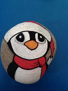 a painted rock with a penguin wearing a red scarf on it's head and eyes