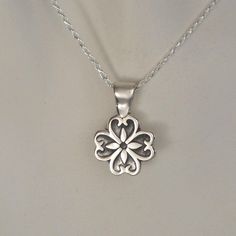 "This sweet sterling silver flower pendant has discreet heart shapes within each petal. It's small size makes it easily dressed up or down. Complimenting women and girls of all ages, this necklace would make a great \"first\" piece of fine jewelry or Sweet 16 gift. The sterling silver flower pendant comes on a hand cast sterling silver bale and an 18 inch sterling silver chain. **If you would like this pendant on a black leather cord, we would be happy to accommodate your request. Our standard m Classic Silver Necklace With Flower Shape, Sterling Silver Charm Necklace With Flower For Mother's Day, Classic Heart Pendant Jewelry With Flower Charm, Mother's Day Sterling Silver Necklace With Flower Charm, Sterling Silver Jewelry For Valentine's Day, Silver Flower Necklace For Anniversary, Hypoallergenic Silver Necklace With Flower Pendant, Silver Hypoallergenic Flower Pendant Necklace, Hypoallergenic Silver Jewelry With Flower Pendant