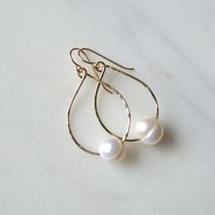 "These simple but gorgeous freshwater pearl earrings feature white or silver freshwater pearls strung onto 19g gold filled or sterling silver wire. Pearls measure approximately 10-11mm and teardrops are 1.25\" long. Please note that pearls are imperfect. They have lines and are not perfectly round." Teardrop 14k Gold Filled Pearl Earrings For Anniversary, Teardrop 14k Gold-filled Pearl Earrings For Anniversary, 14k Gold Filled Teardrop Pearl Earrings For Anniversary, Nickel-free Teardrop Pearl Earrings, Wire Wrapped Teardrop Pearl Jewelry, Minimalist Wire Wrapped Pearl Drop Earrings, Wire Wrapped Pearl Teardrop Earrings, Elegant Wire Wrapped Teardrop Pearl Earrings, Elegant Teardrop Wire Wrapped Pearl Earrings