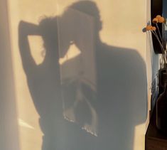 the shadow of a person standing in front of a refrigerator