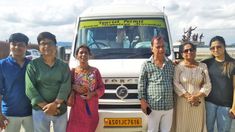 a group of people standing in front of a bus