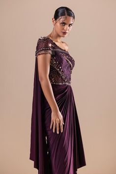 Burgundy lycra and net draped saree gown with Swarovski, crystals, cutdana and sequins hand embroidery. - Aza Fashions Evening Gown With Traditional Pre-draped Style, Pre-draped Evening Gown With Traditional Drape, Evening Gown With Pre-draped Traditional Drape, Embellished One-shoulder Evening Saree, Evening One Shoulder Embellished Pre-draped Saree, Evening One-shoulder Embellished Pre-draped Saree, Fitted Dress With Draped Sleeves, Fitted Pre-draped Saree For Gala, Fitted Evening Dress With Traditional Drape