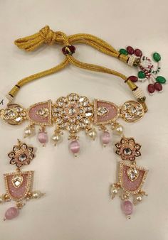 One of our favorite picks for the wedding season 2022♥️ The gorgeous choker is beautifully handcrafted by our skilled Indian craftsmen in Kundan stones, pink beads, mini pearls, and gold plated. The beautiful Kundan earrings add to the traditional ethnicity of the piece. Material: Brass with gold plating Length of earrings: 6.5 cms Width of earrings: 2 cms Bridal Choker Set, Indian Choker, Kundan Choker, Bridal Choker, Kundan Earrings, Choker Set, Pink Beads, Wedding Season, Indian Jewelry