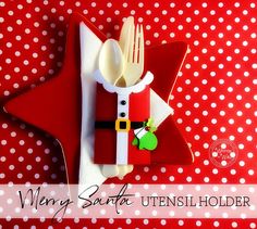 a red and white plate topped with a knife and fork next to a christmas decoration