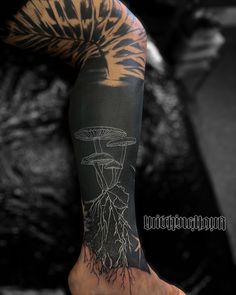 a man's arm with a mushroom and tree tattoo design on it, in black and white