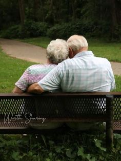 an older couple sitting on a bench in the park looking out at the grass and trees