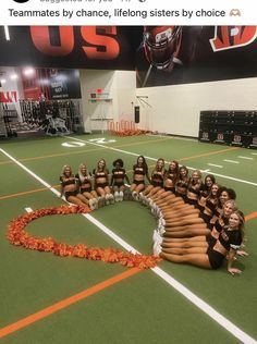 a group of cheerleaders sitting on top of a football field