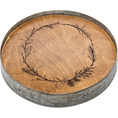 a round wooden tray with an etched design on the front and bottom, sitting on a white background