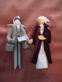 two doll figurines, one holding a key chain and the other wearing a coat