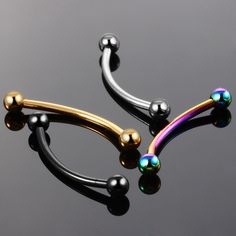 two different colored balls are attached to the end of a pair of nose piercings