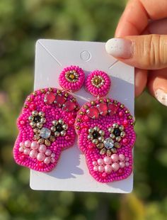 Lovely sugar skull earrings now available and three beautiful colors! (Look at all those gorgeous gems, beads and pearls 🌟Buy 10 get extra 10% off at check out! Code: BUY10OFF10 🌟These earrings are super light weight! (So light that you forget you have them on!) 🌟Perfect gift for her or for yourself! (Get ready to attract some attention!) 🌟So adorable and sparkly! (Much better in person😉) 🎇Approximate length: 2.5-3 inches (Each made with love and care) 💎Message me for Bulk pricing 🌟Also Beaded Skull Earrings, Skeleton Beaded Earrings, Beaded Sugar Skull Earrings, Polymer Clay Sugar Skull Earrings, Embroidery Earrings, Sugar Skull Earrings, Skeleton Earrings, Pink Cocktails, Bottle Earrings