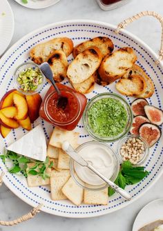 a white plate topped with lots of different types of cheeses and crackers on top of a table