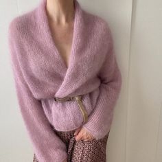 a woman is wearing a pink sweater and skirt