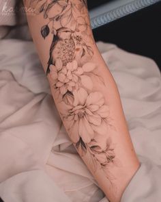 a woman's leg with flowers and leaves on the top part of her arm