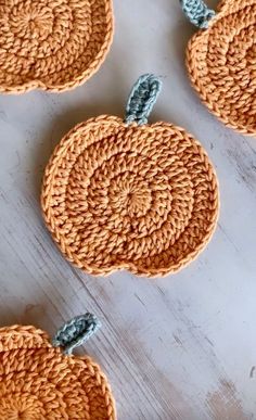 four crocheted pumpkins are sitting on the table