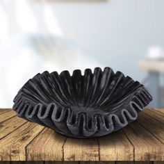 a black bowl sitting on top of a wooden table