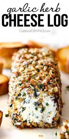 garlic herb cheese log on a white plate with crackers and bread in the background