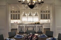 a dining room table with place settings and plates on it in front of an island