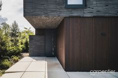 a modern house with wood siding and black doors