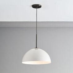 a white light hanging from the ceiling in a room with gray walls and flooring