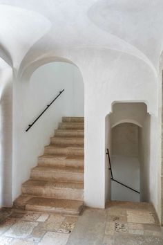 an empty hallway with stone steps leading up to the second floor