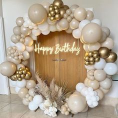 a happy birthday balloon arch with white and gold balloons on the front door to a house