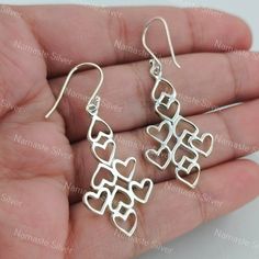 Elevate your style with these exquisite handcrafted silver dangle earrings. Each earring features a unique geometric heart design meticulously crafted from high-quality 925 sterling silver. The interlocking hearts create an elegant cascading effect, perfect for adding a touch of sophistication to any outfit. The lightweight construction ensures comfortable wear, while the secure hook backing provides ease of use. Whether for a special occasion or everyday elegance, these earrings are a must-have Silver Dangle Heart Earrings, Handmade Sterling Silver Heart Earrings For Mother's Day, Handmade Silver Heart Earrings For Valentine's Day, Valentine's Day Sterling Silver Dangle Heart Earrings, Nickel-free Sterling Silver Dangle Heart Earrings, Sterling Silver Dangle Heart Earrings, Sterling Silver Heart Drop Earrings, Valentine's Day Teardrop Sterling Silver Heart Earrings, Silver Minimalist Heart Dangle Earrings