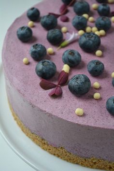 a cake with blueberries on it sitting on a plate