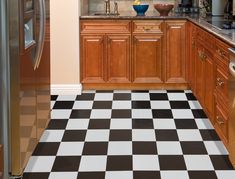 a black and white checkered floor in a kitchen next to a metallic refrigerator freezer