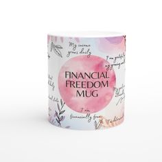 a white coffee mug with the words financial freedom on it and pink watercolor paint