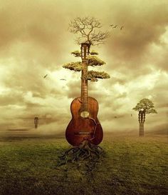 a guitar sitting in the middle of a field with trees growing out of its back