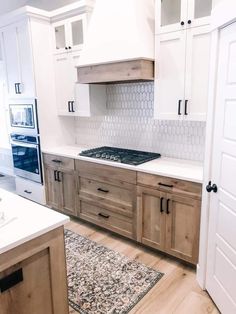 a kitchen with white cabinets and wood flooring is pictured in this image from the front door