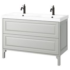 two white sinks sitting on top of a wooden cabinet with black faucet handles