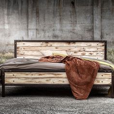 a bed made out of wood with a brown blanket on it's headboard