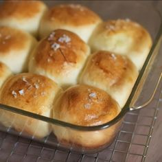 baked rolls in a glass baking dish on a wire rack