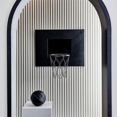 a basketball hoop mounted to the side of a wall next to a black and white ball