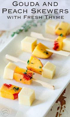 several pieces of cheese on skewers with fresh thyme gaudia and peaches