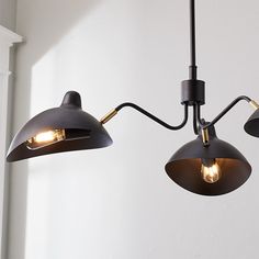 three lights are hanging from the ceiling in a room with white walls and flooring