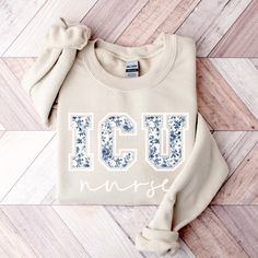 a sweater with the word iceu in white and blue on it sitting on a wooden floor