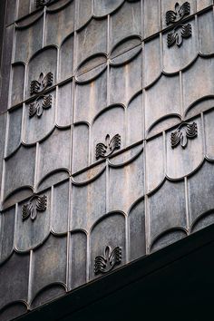 an intricately designed metal wall with flowers on it's sides and leaves in the middle