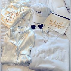 white clothes and accessories laid out on a bed