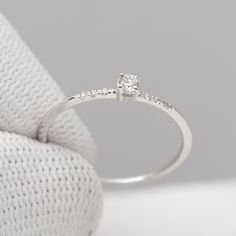 a diamond ring sitting on top of a white cloth