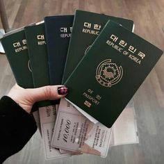 a person holding four passport cards in their hand with the words republic of korea written on them